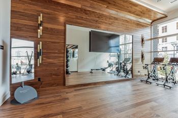 A gym with wood floors and a tv on the wall